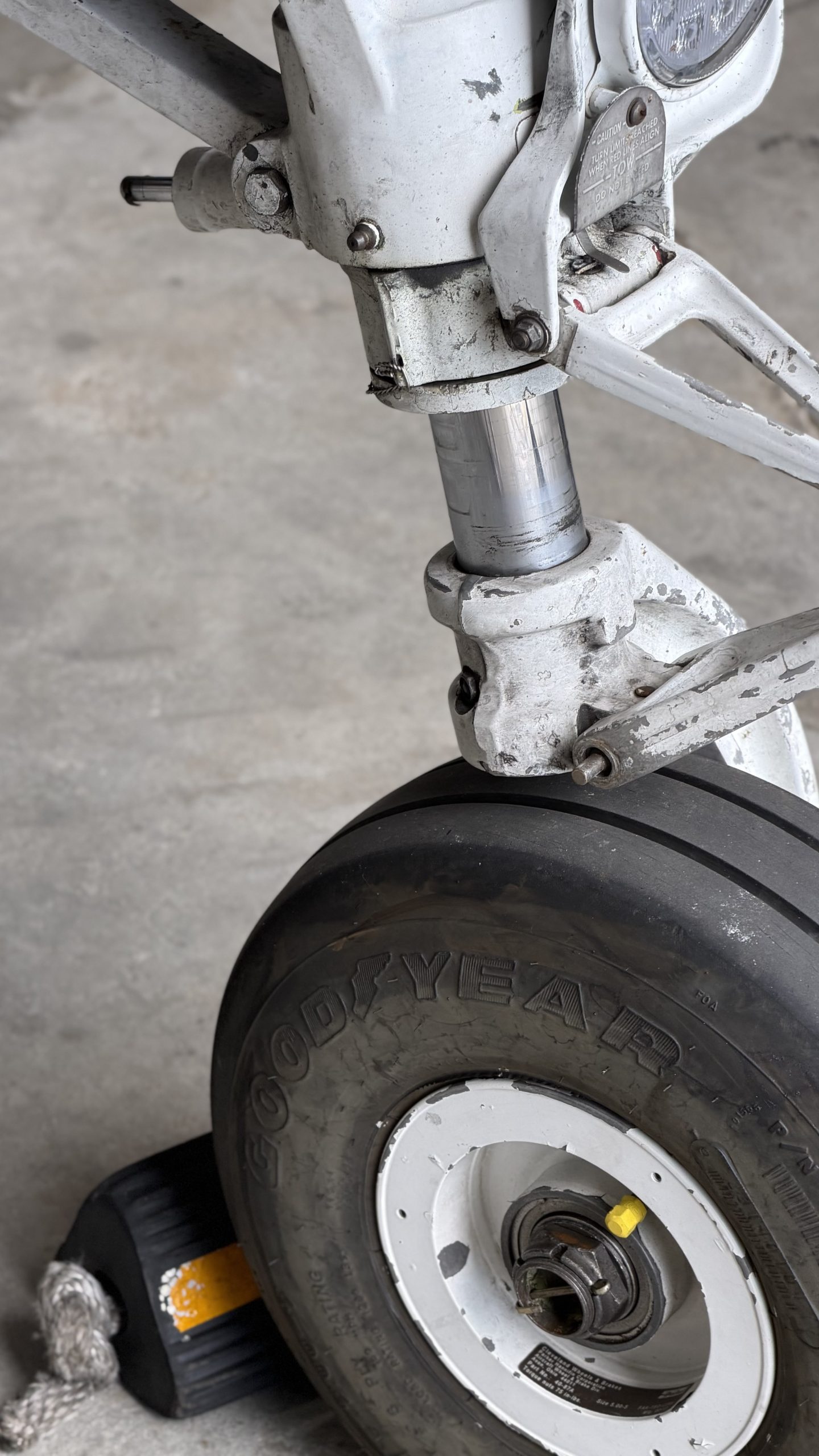 Close view of an aircraft landing gear assembly and wheel during maintenance