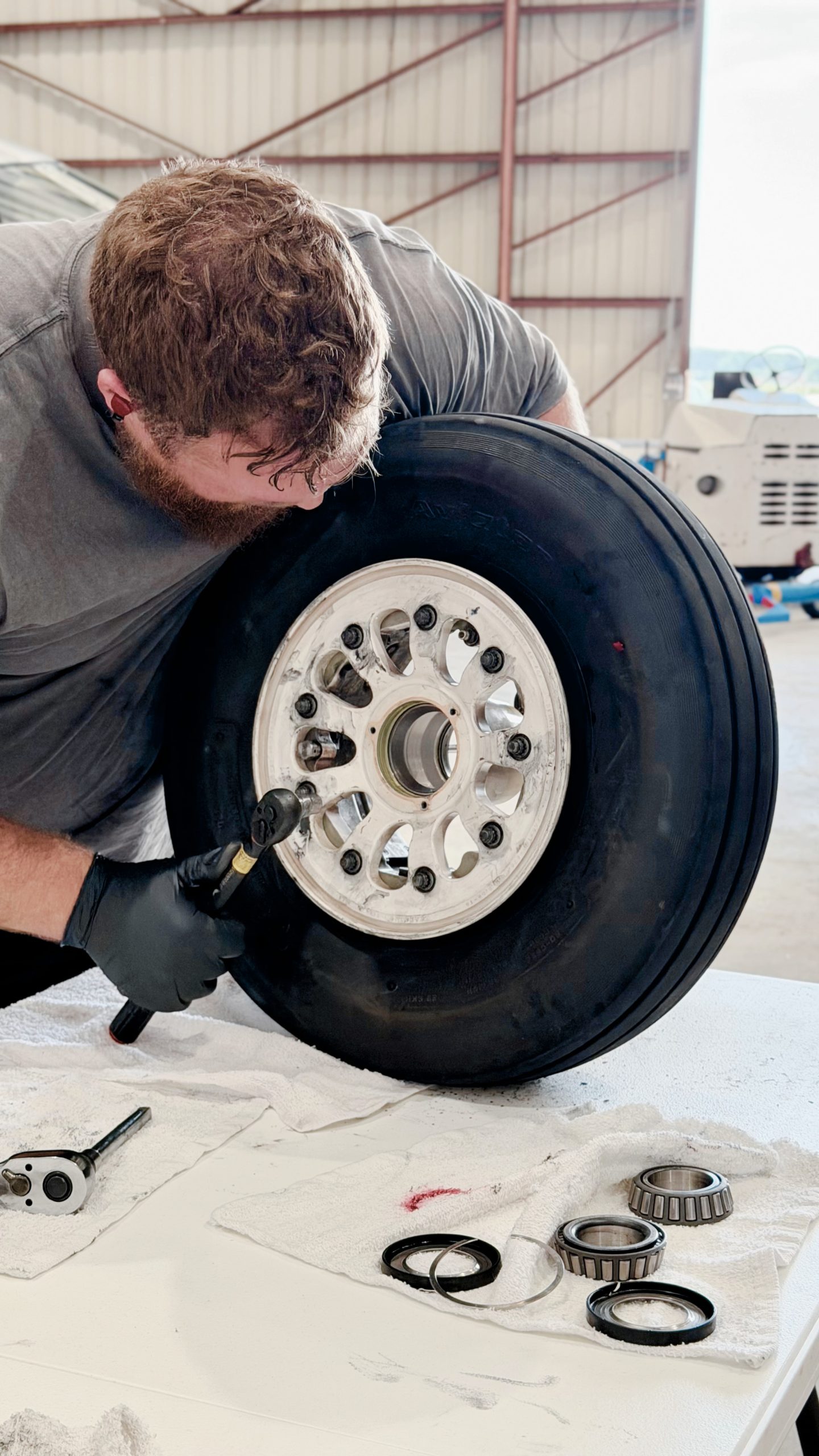 Aircraft maintenance technicians inspecting an open service panel in a hangar
